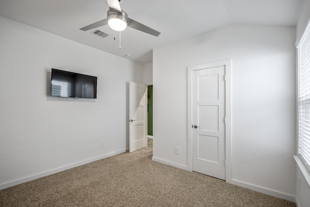 unfurnished bedroom featuring ceiling fan, light carpet, and vaulted ceiling