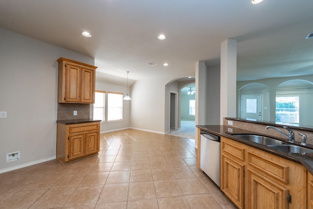 kitchen featuring backsplash, sink, light tile patterned floors, and stainless steel dishwasher