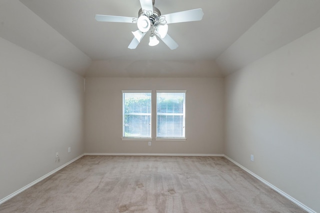 carpeted spare room featuring ceiling fan and vaulted ceiling