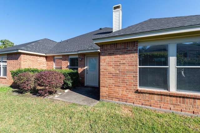 doorway to property featuring a lawn