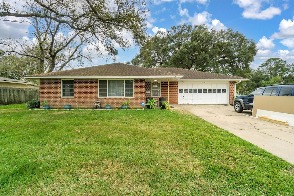 single story home featuring a garage and a front lawn