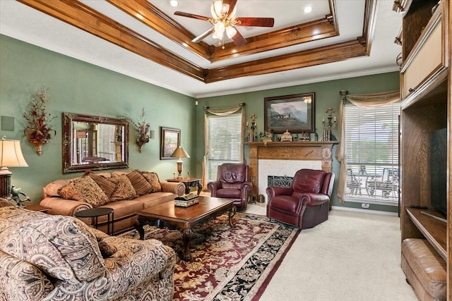 living room with light carpet, a raised ceiling, ceiling fan, and ornamental molding