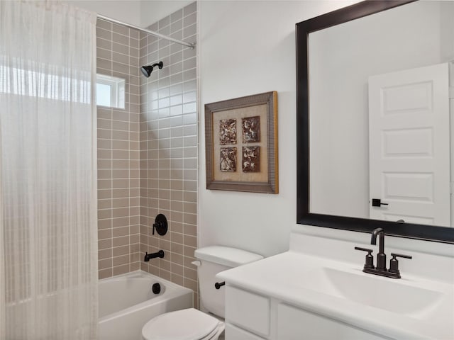 full bathroom featuring vanity, tiled shower / bath combo, and toilet