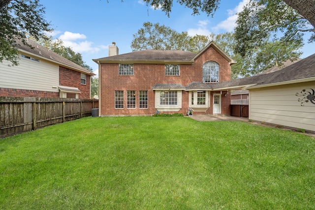 rear view of property featuring central AC unit and a yard