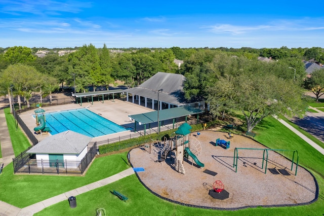 view of swimming pool featuring a playground and a lawn