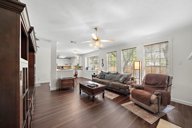 living room featuring crown molding, ceiling fan, dark hardwood / wood-style flooring, and a textured ceiling