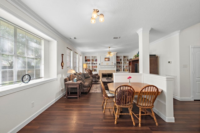 dining room featuring a textured ceiling, built in shelves, crown molding, and dark wood-type flooring