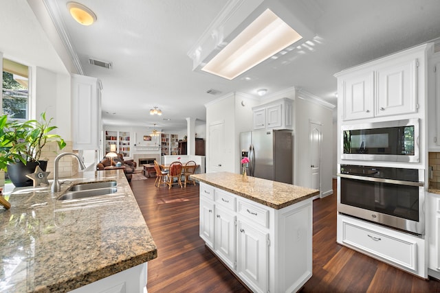 kitchen with stainless steel appliances, crown molding, sink, dark hardwood / wood-style floors, and white cabinetry