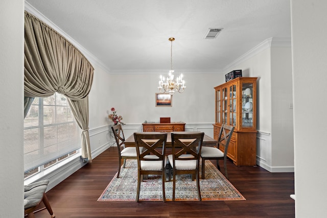 dining space featuring a chandelier, crown molding, and dark wood-type flooring