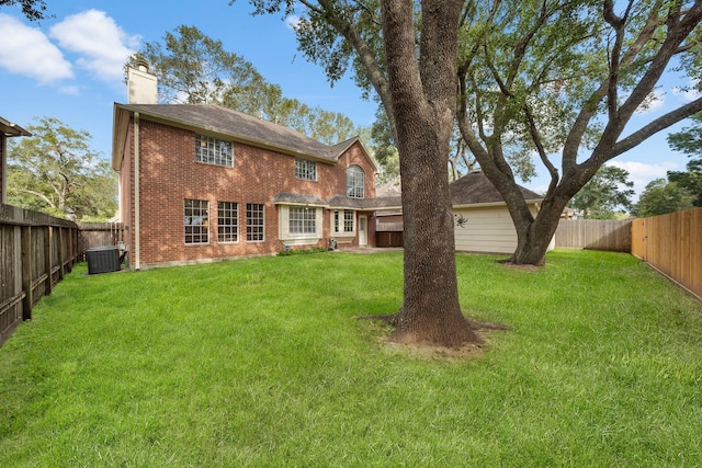 rear view of property with a yard and central AC unit