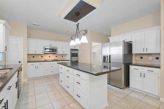 kitchen with white cabinets, appliances with stainless steel finishes, and tasteful backsplash