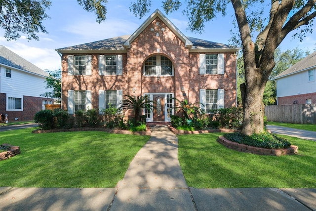 colonial-style house featuring a front yard