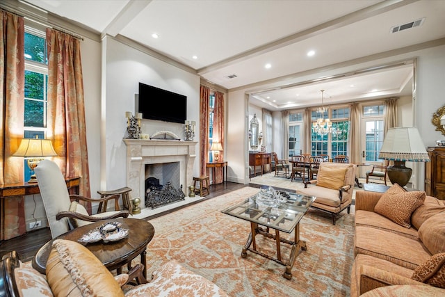 living room featuring a wealth of natural light, a notable chandelier, and hardwood / wood-style flooring