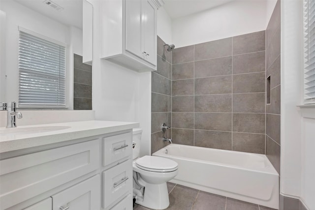 full bathroom featuring tile patterned floors, vanity, toilet, and tiled shower / bath