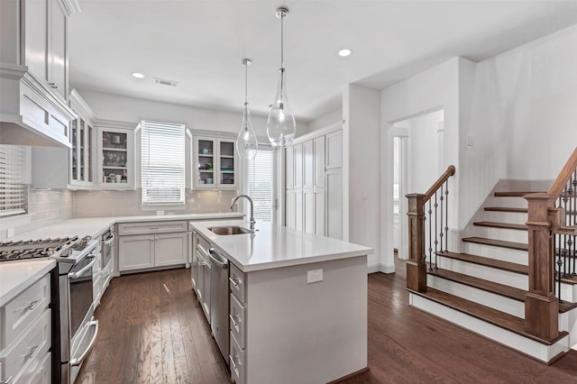 kitchen featuring a kitchen island with sink, dark wood-type flooring, white cabinets, sink, and stainless steel appliances