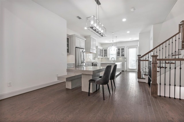 dining space featuring a notable chandelier, sink, and dark wood-type flooring