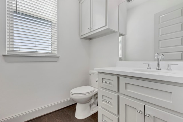 bathroom with hardwood / wood-style floors, vanity, and toilet