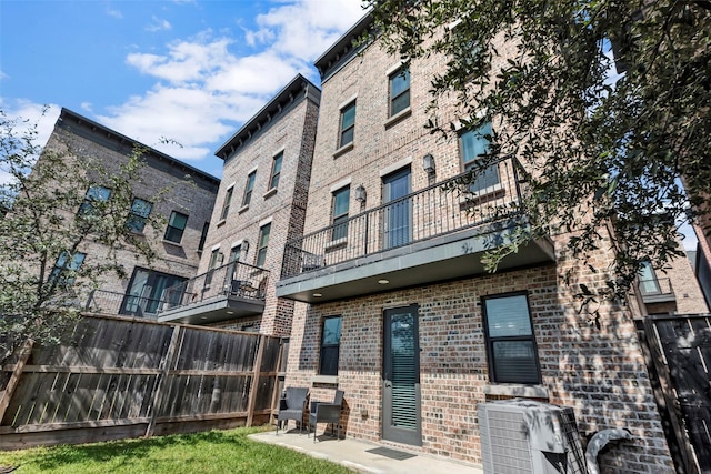 back of house with central AC unit and a balcony