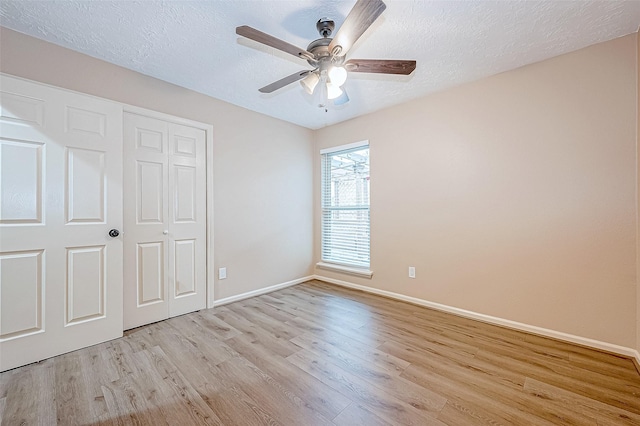 unfurnished bedroom with a closet, ceiling fan, light hardwood / wood-style flooring, and a textured ceiling