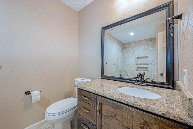 bathroom with vanity, toilet, and a textured ceiling