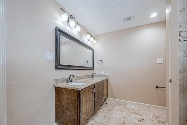 bathroom with vanity and a textured ceiling