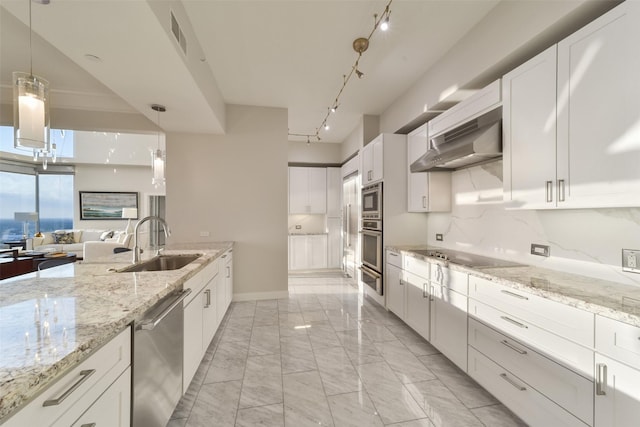 kitchen featuring stainless steel appliances, white cabinetry, sink, and hanging light fixtures