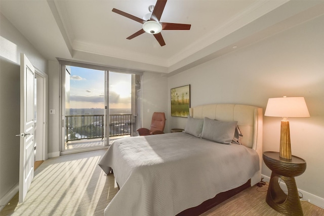 bedroom featuring ceiling fan, a tray ceiling, ornamental molding, and access to exterior