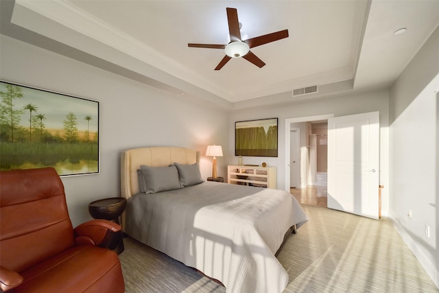 bedroom with ceiling fan and a raised ceiling