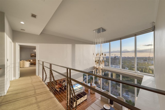 corridor featuring a wall of windows and an inviting chandelier