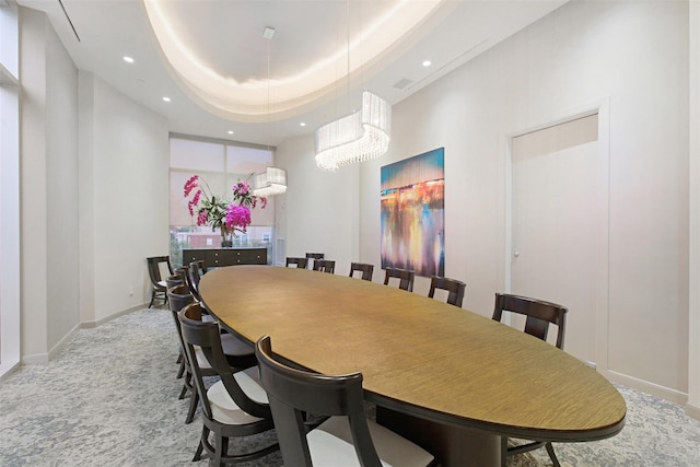 dining space with a raised ceiling and an inviting chandelier