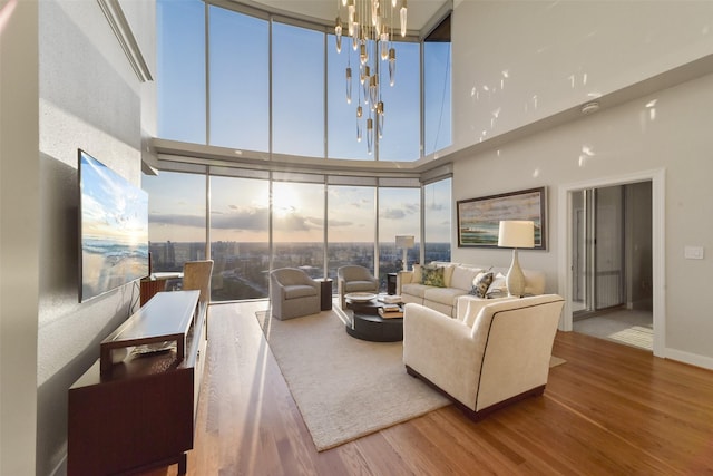 living room featuring a high ceiling, a notable chandelier, and hardwood / wood-style flooring