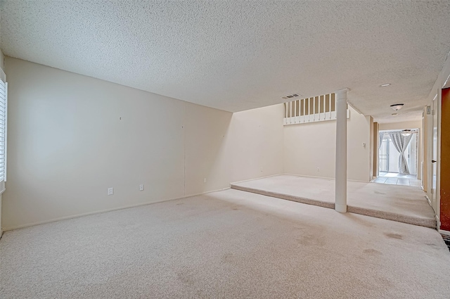 spare room featuring a textured ceiling and carpet floors