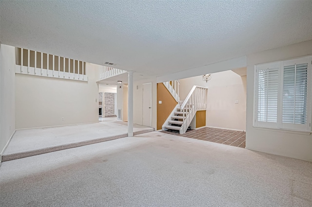 carpeted empty room featuring a textured ceiling and an inviting chandelier