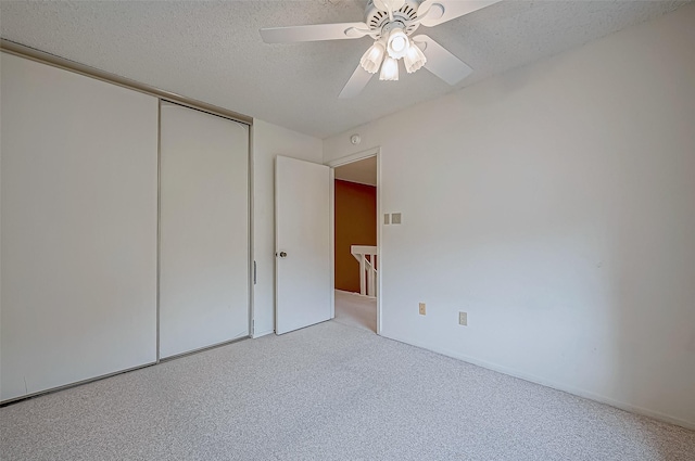 unfurnished bedroom featuring ceiling fan, a textured ceiling, and a closet