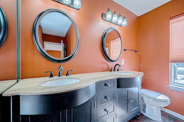 bathroom with vanity, a textured ceiling, and toilet