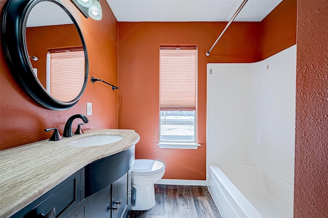 full bathroom featuring hardwood / wood-style floors, vanity,  shower combination, and toilet