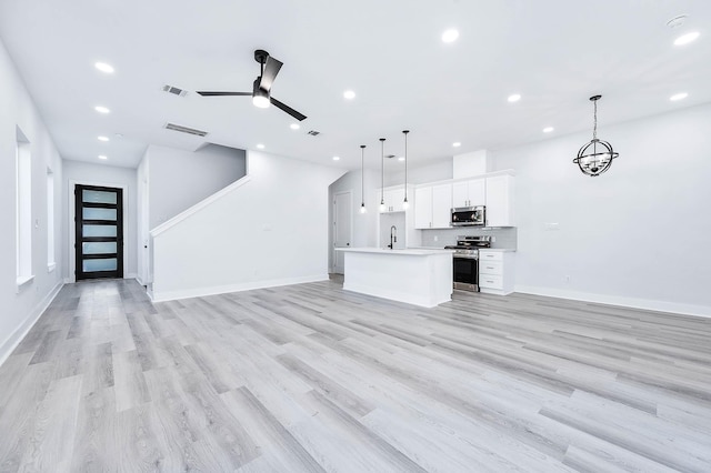 unfurnished living room with light wood-type flooring and ceiling fan