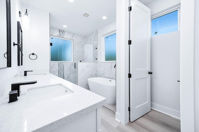 bathroom with hardwood / wood-style flooring, vanity, separate shower and tub, and tile walls