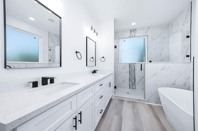 bathroom featuring hardwood / wood-style floors, vanity, and separate shower and tub