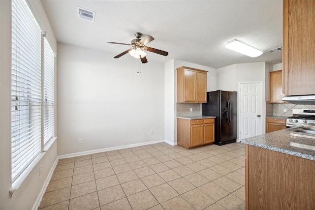 kitchen featuring backsplash, black fridge with ice dispenser, gas stove, ceiling fan, and light tile patterned flooring