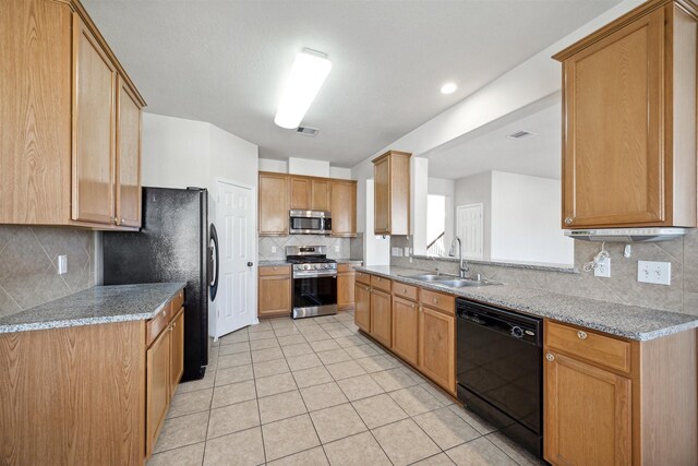 kitchen featuring light stone countertops, sink, decorative backsplash, light tile patterned flooring, and black appliances