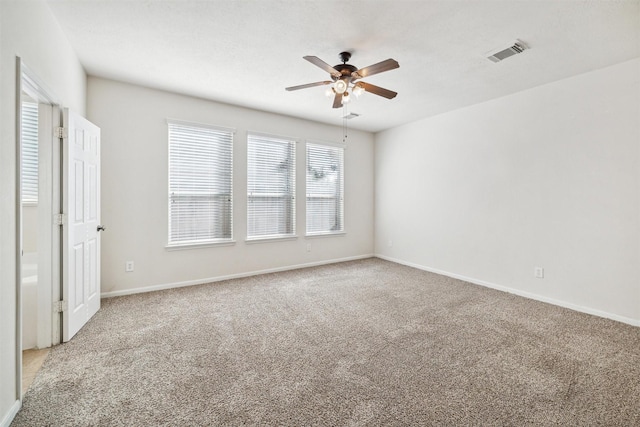 carpeted spare room with ceiling fan