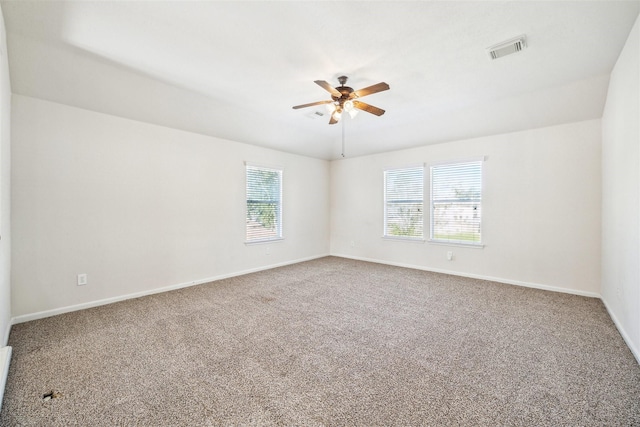 empty room featuring ceiling fan, plenty of natural light, and carpet