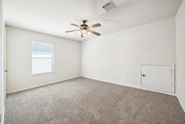 empty room featuring ceiling fan and carpet