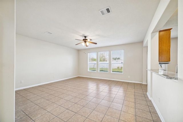 tiled spare room with ceiling fan