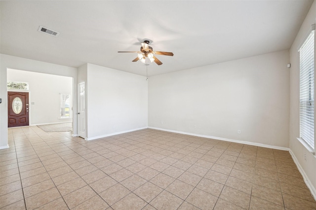 tiled spare room featuring ceiling fan