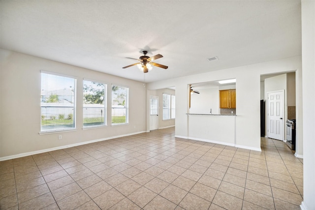 unfurnished living room featuring light tile patterned floors and ceiling fan