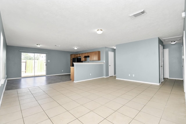 unfurnished living room with light tile patterned floors and a textured ceiling