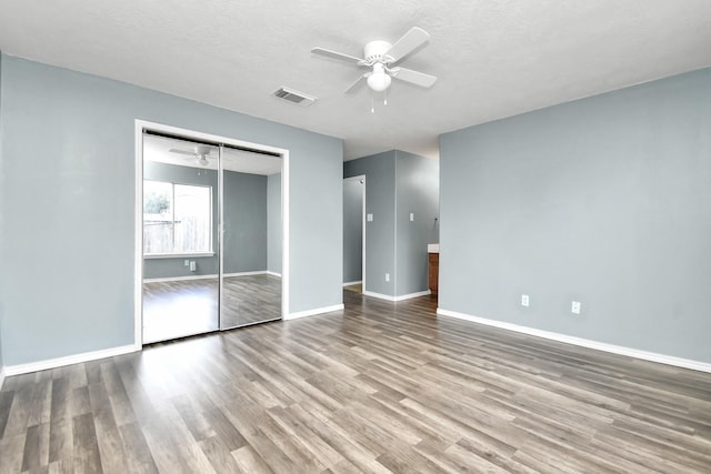 unfurnished bedroom with ceiling fan, light hardwood / wood-style floors, a textured ceiling, and a closet