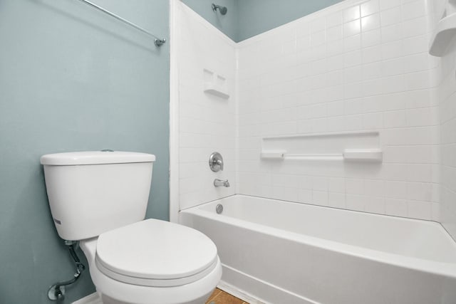 bathroom featuring tiled shower / bath combo and toilet